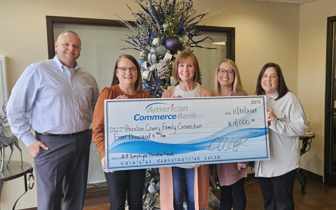 A group people holding an ACB check for their jeans friday donation.